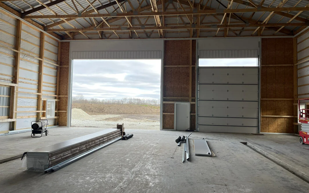 Technician performing commercial garage door repair on a metal door at a business property in Clintonville, ensuring proper functionality and security.