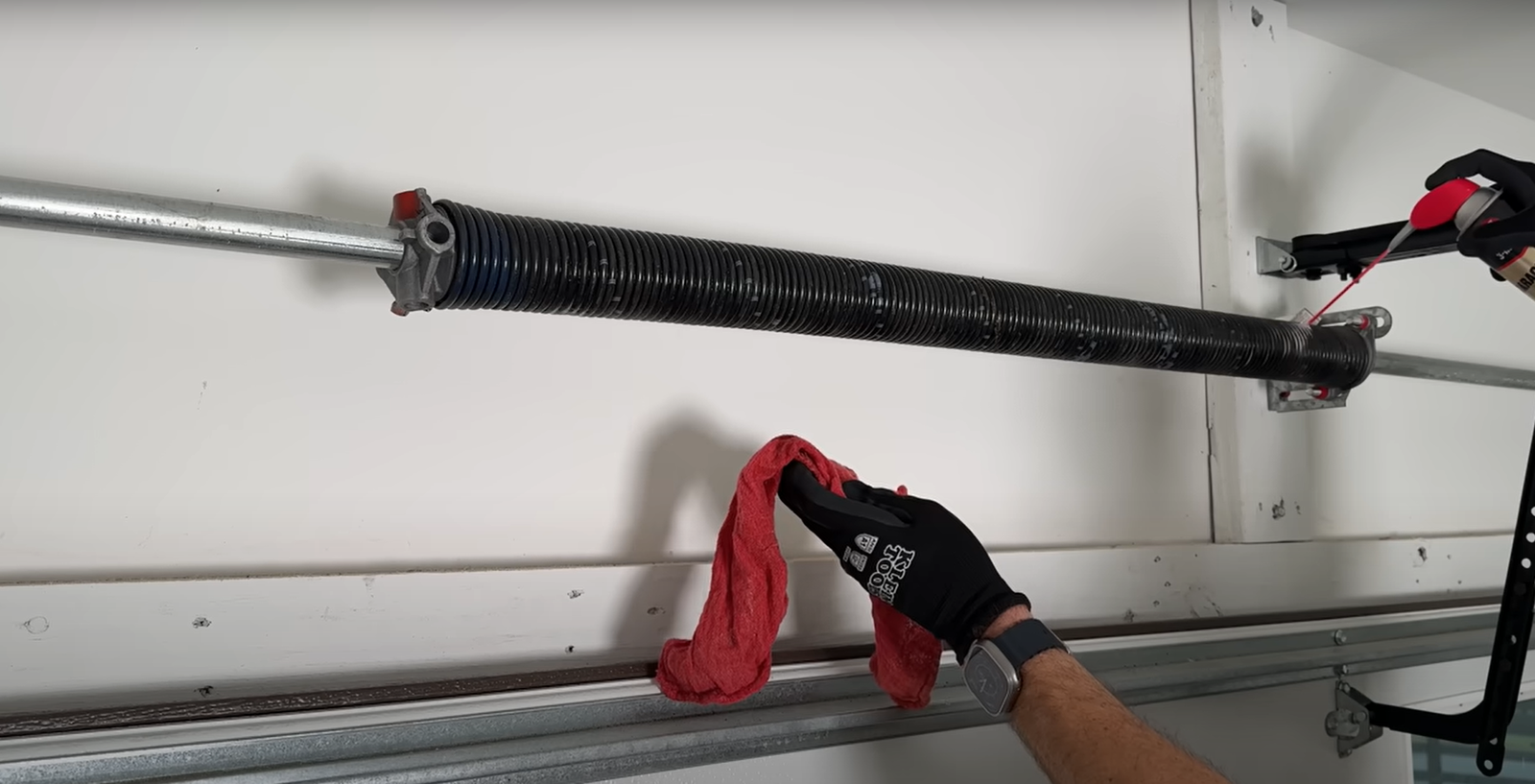 Technician performing a garage door spring repair on a residential door in Clintonville.