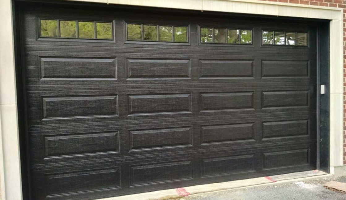 Technician performing a garage door section replacement for a residential property in Clintonville, highlighting professional repair services
