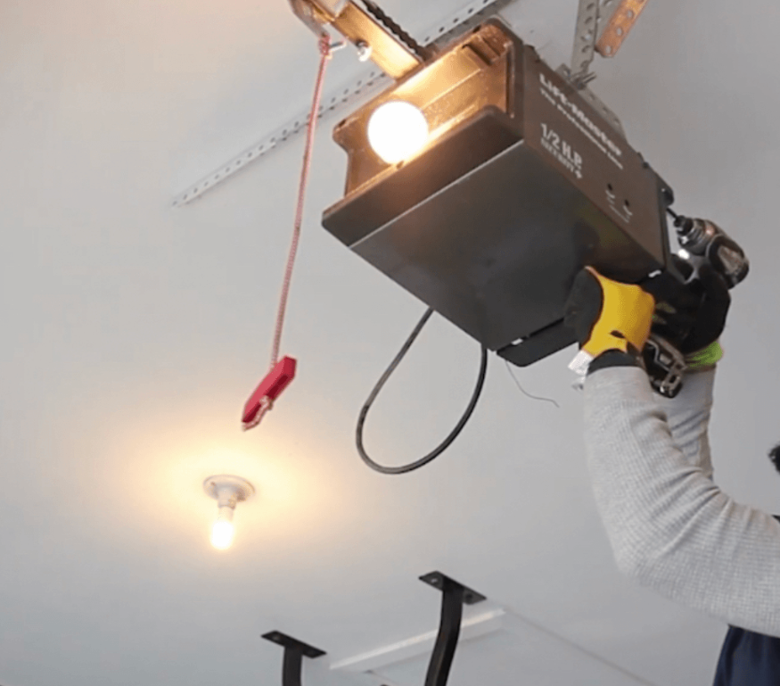 Technician installing a modern garage door opener in a residential garage, showcasing professional Clintonville garage door repair services.