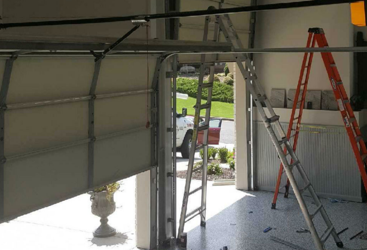 a skilled technician performing a garage door repair, showcasing Clintonville Garage Door Repair LLC's expertise in fixing residential garage doors.