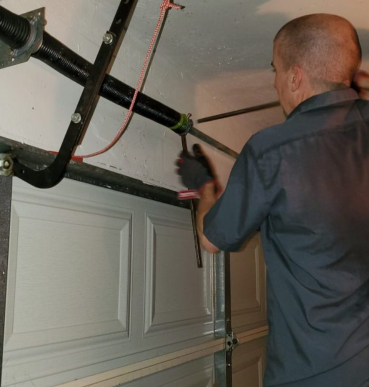 Garage door spring repair service by Clintonville Garage Door Repair LLC, featuring a technician fixing a garage door spring in a residential garage.