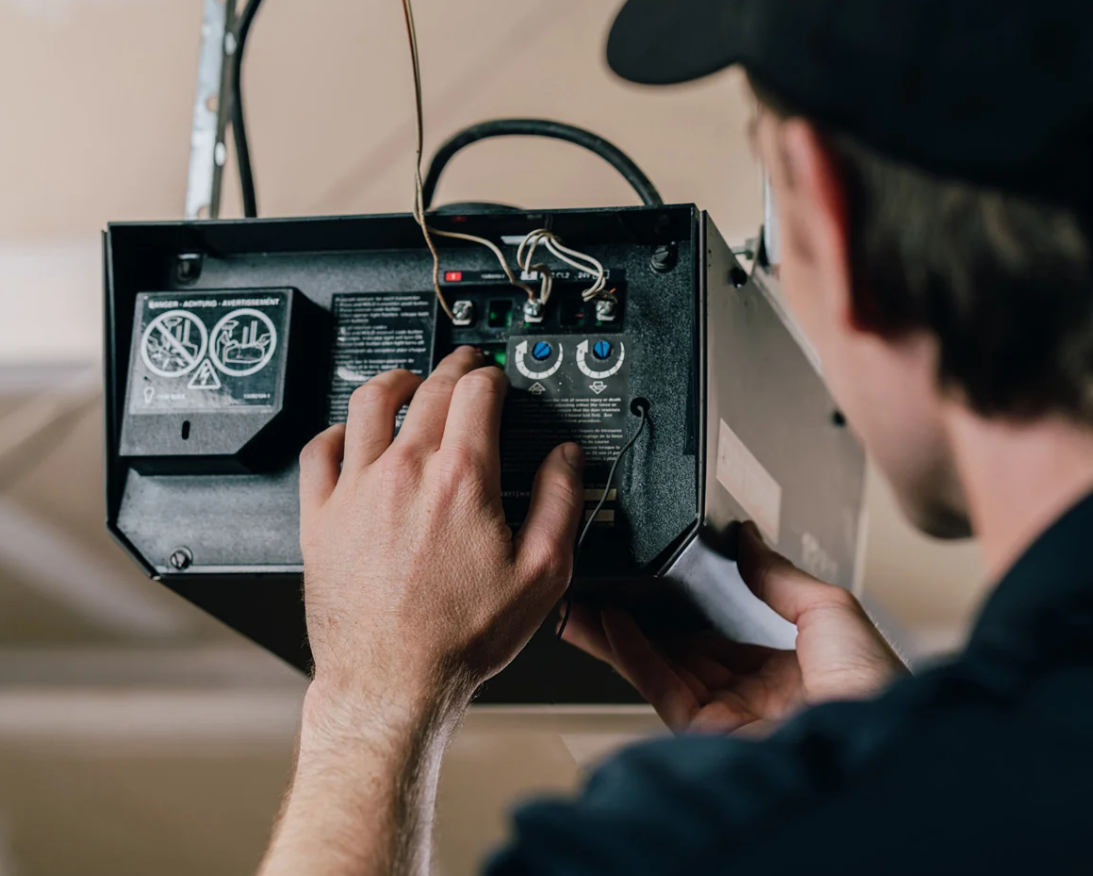 Technician performing garage door opener repair on residential garage in Clintonville - Clintonville Garage Door Repair LLC